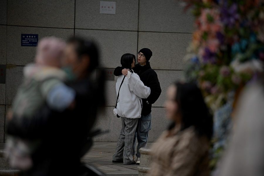 A couple hugs at a shopping centre in Chengdu, Sichuan province, China, on 28 November 2020. (Noel Celis/AFP)