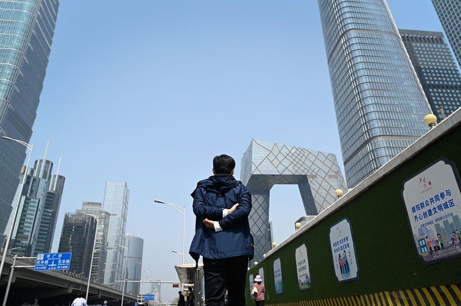 A man walks along a street in the central business district in Beijing, China, on 18 April 2022. (Wang Zhao/AFP)