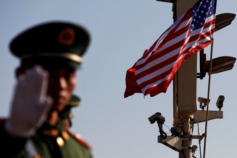 A paramilitary policeman gestures under a pole with security cameras, U.S. and China's flags, near the Forbidden City, ahead of a visit by U.S. President Donald Trump to Beijing, 8 November 2017. (Damir Sagolj/REUTERS)
