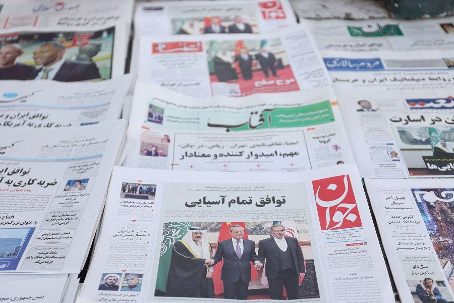 A newspaper with a cover picture of the Iranian secretary of the Supreme National Security Council, Rear Admiral Ali Shamkhani; the Saudi Minister of State and national security adviser Musaed bin Mohammed Al-Aiban; and China's member of the Politburo and director of the Office of the Central Foreign Affairs Commission, Wang Yi, is seen in Tehran, Iran, 11 March 2023. (Majid Asgaripour/WANA (West Asia News Agency) via Reuters)
