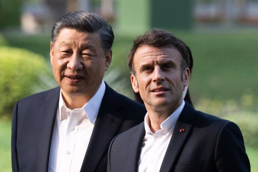 Chinese President Xi Jinping (left) and French President Emmanuel Macron (right) visit the garden of the residence of the Governor of Guangdong, on 7 April 2023, where Chinese President XI Jinping's father Xi Zhongxun lived. (Jacques Witt/AFP)