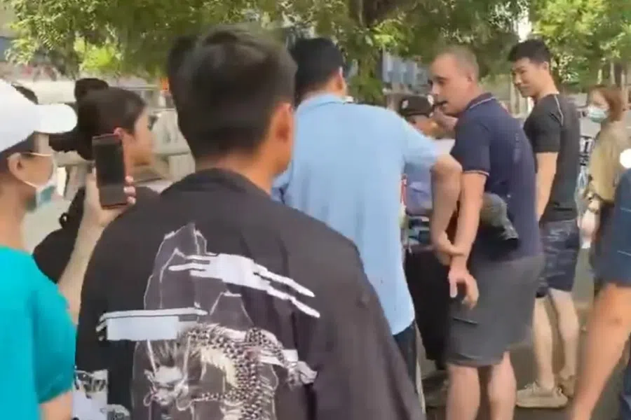 A screen grab from a video showing Mathias Boelinger surrounded by people in Zhengzhou. (Twitter/Mathias Boelinger@mare_porter)