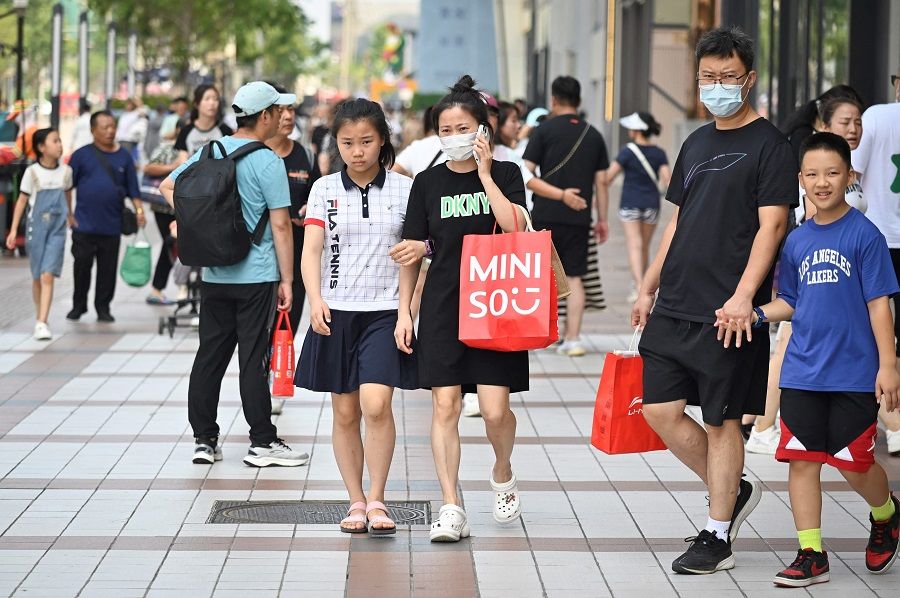 People visit a business street in Beijing on 15 August 2023. (Wang Zhao/AFP)