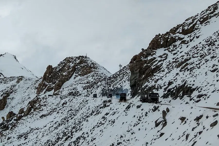 Indian Army vehicles drive on a road near Chang La high mountain pass in northern India's Ladakh region of Jammu and Kashmir state near the border with China on 17 June 2020. (STR/AFP)