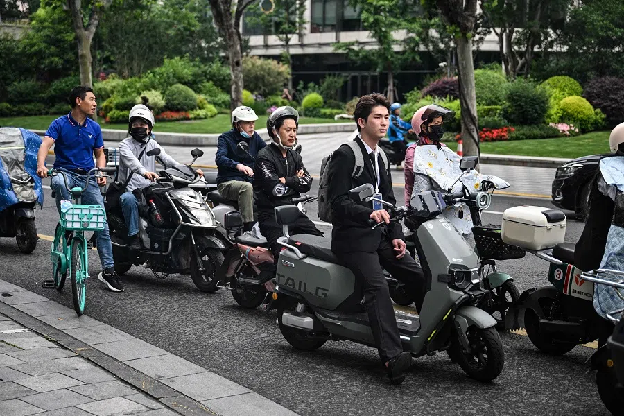 People wait to cross a street in the Jing’an district in Shanghai, China, on 5 June 2024. (Hector Retamal/AFP)