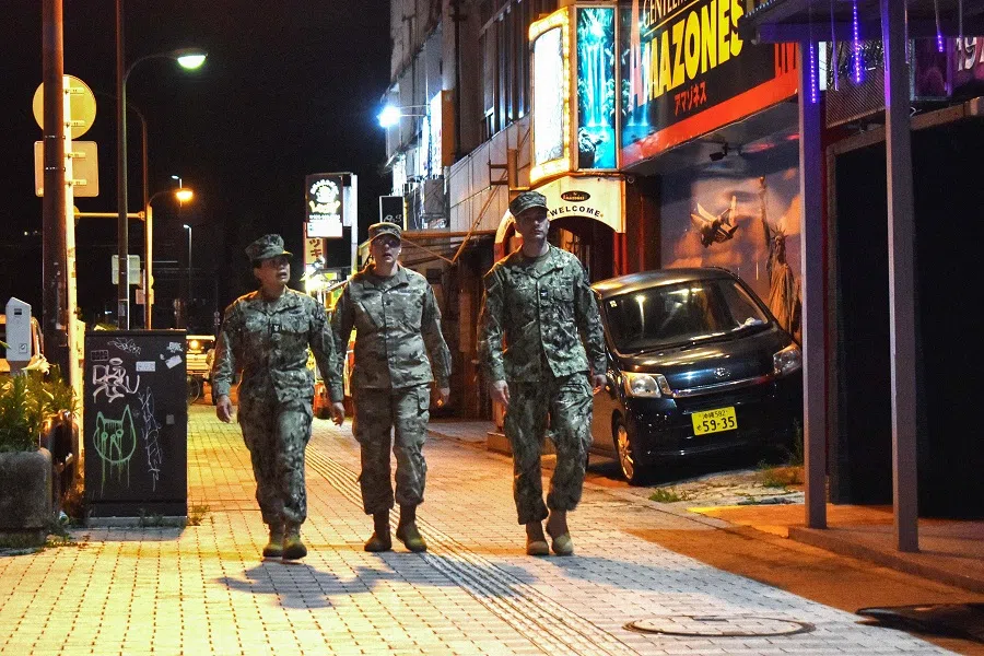 US military personnel are pictured walking down a street in Okinawa city, Okinawa prefecture late on 18 April 2025. (Hiroaki Yamashiro/AFP)