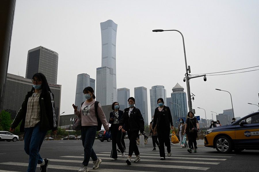 People commute at the central business district in Beijing, China, on 21 April 2022. (Jade Gao/AFP)