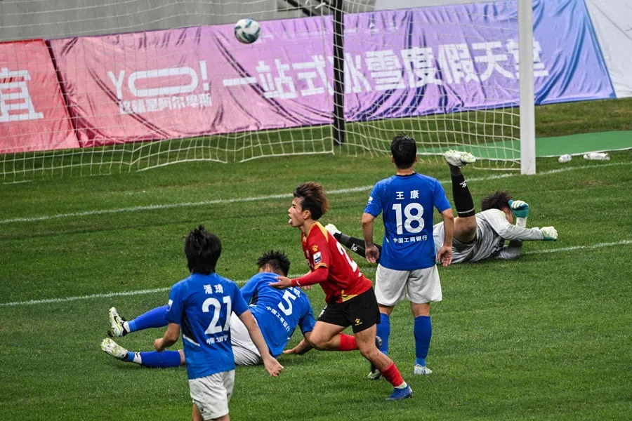 A Suzhou amateur football player celebrates after scoring against Yangzhou at the Kunshan Olympic Sport Center in Kunshan, in eastern China’s Jiangsu province on 29 June 2025. (Hector Retamal/AFP)