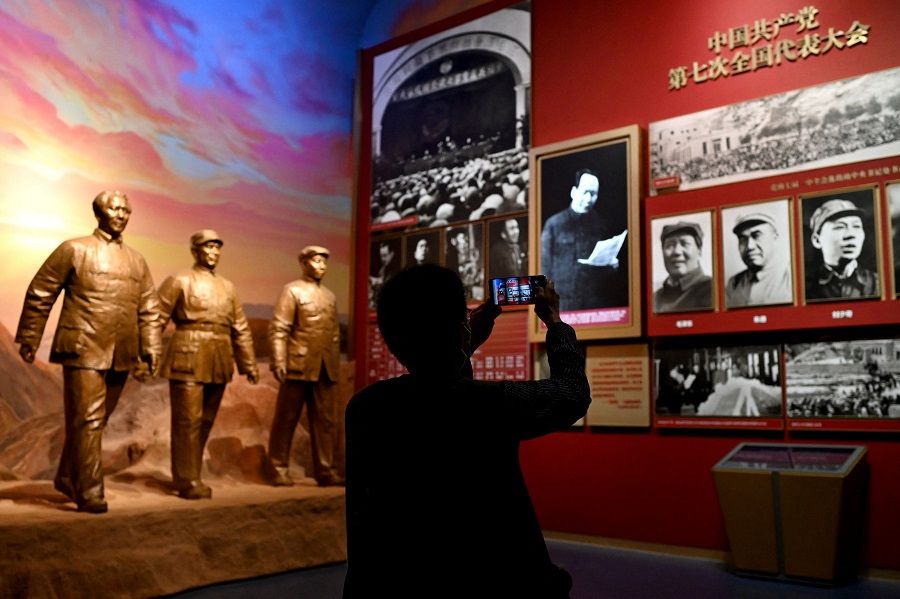 A journalist takes a photo of pictures depicting late Communist leader Mao Zedong, during a visit to the Museum of the Communist Party of China, near the Bird's Nest national stadium in Beijing, China, on 25 June 2021. (Noel Celis/AFP)