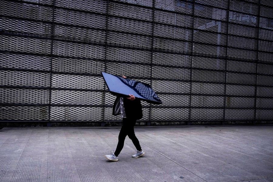 A person carries a computer monitor at Semicon China, a trade fair for semiconductor technology, in Shanghai, China, 17 March 2021. (Aly Song/Reuters)