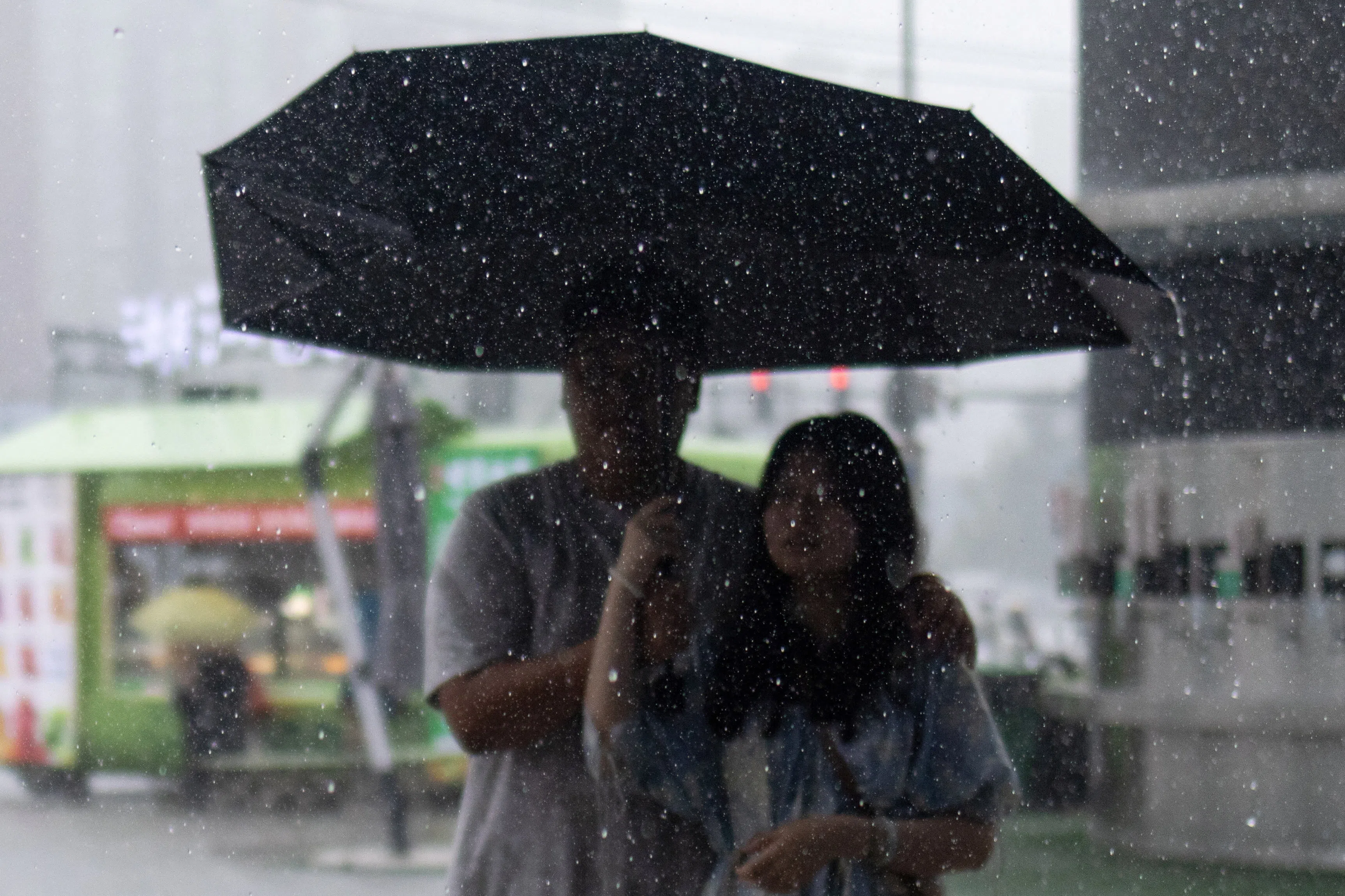 Raindrops fall as a couple walks with an umbrella under heavy rain shower in Beijing, China, on 10 July 2026.