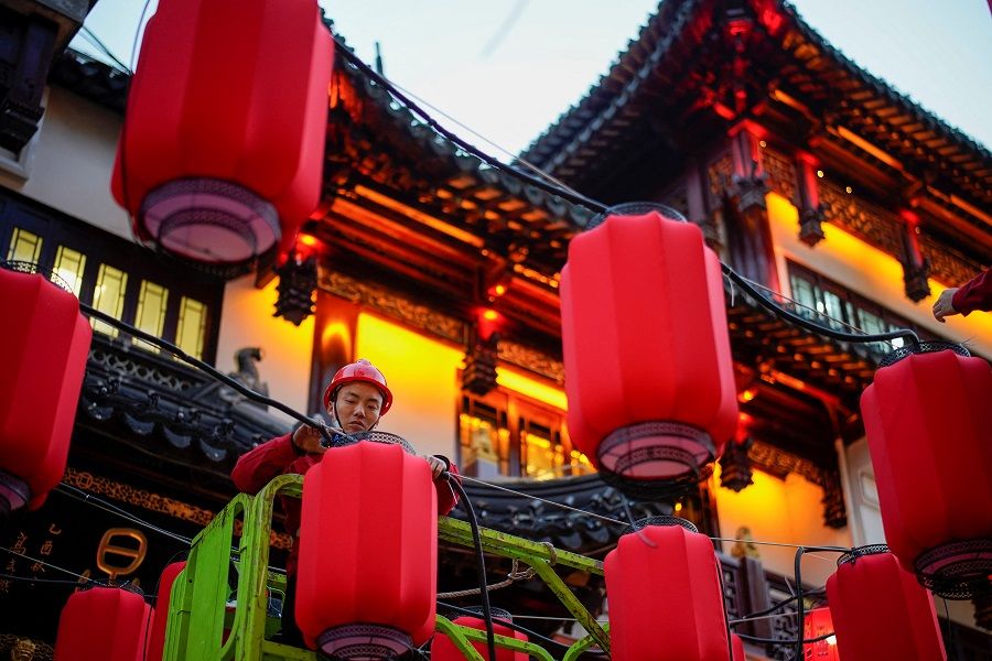 A worker installs lanterns ahead of the Chinese New Year at Yu Garden, in Shanghai, China, 18 January 2022. (Aly Song/Reuters)