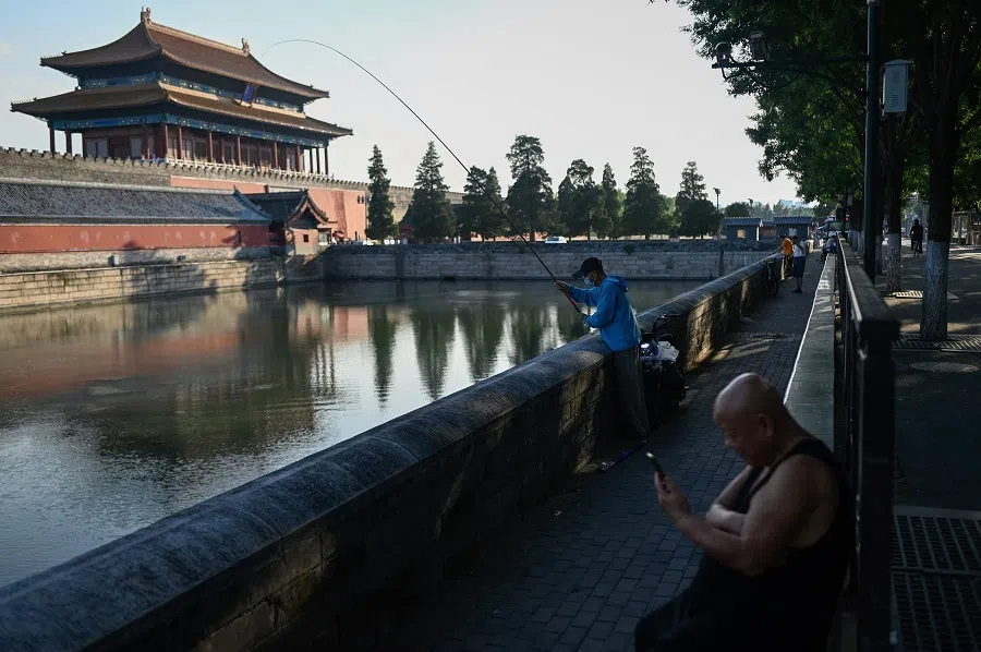 An angler fishes outside the Forbidden City in Beijing, China, on 13 July 2022. (Wang Zhao/AFP)
