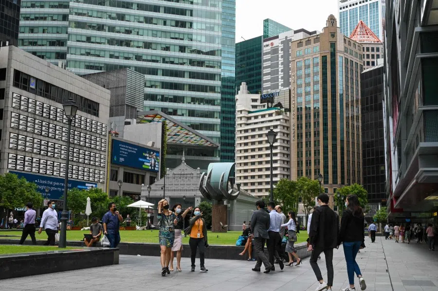 Office workers walk out for lunch break at Raffles Place financial business district in Singapore on 4 January 2022. (Roslan Rahman/AFP)
