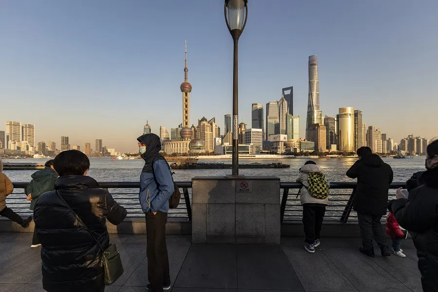 Pedestrians walk along the Bund past buildings in the Lujiazui Financial District across the Huangpu River in Shanghai, China, on 28 December 2021. (Qilai Shen/Bloomberg)