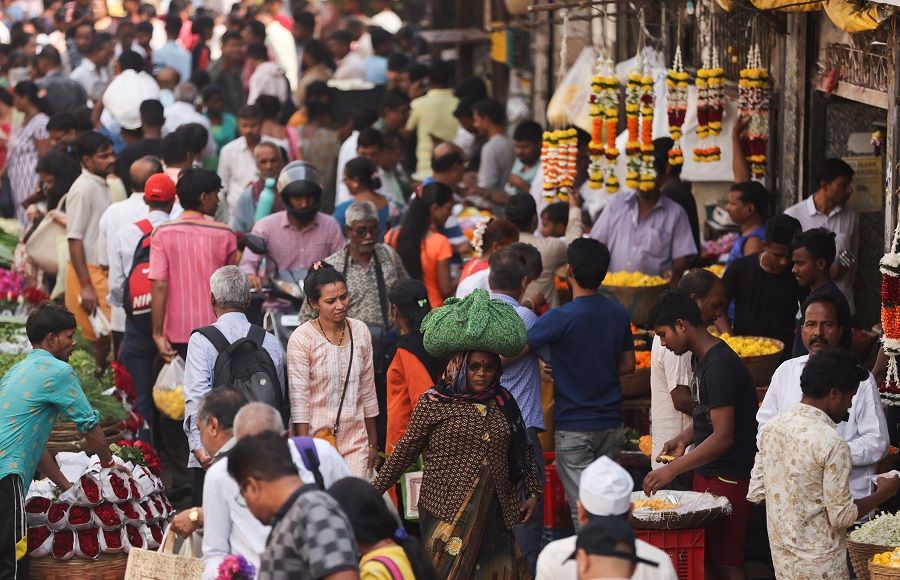 People walk through a crowded market in Mumbai, India, 22 December 2022. (Francis Mascarenhas/Reuters)