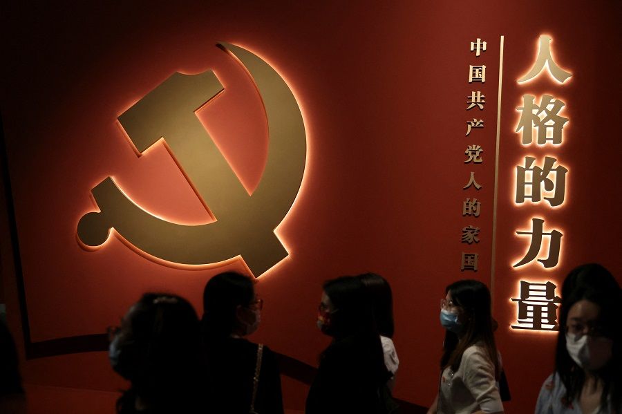 Visitors stand near the party emblem at an exhibition on the Chinese Communist Party ahead of its 101st founding anniversary, at the National Museum in Beijing, China, 30 June 2022. (Tingshu Wang/Reuters)