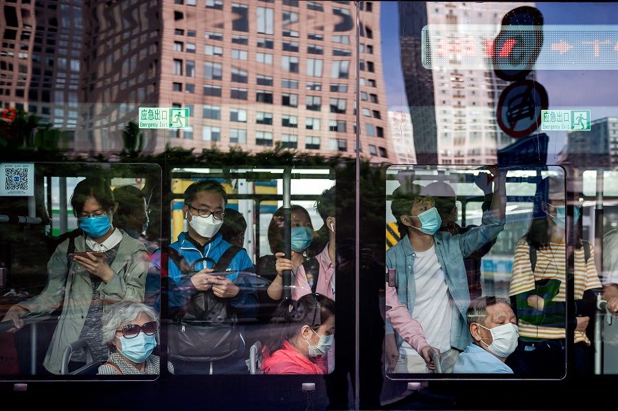 People commute on a bus during morning rush hour in Beijing on 22 May 2020. (Nicolas Asfouri/AFP)