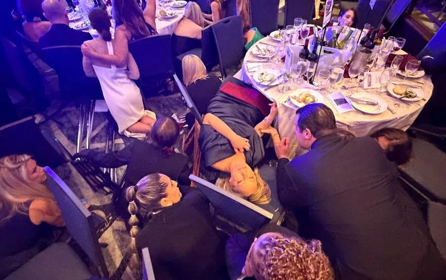 Guests take cover after US President Donald Trump and first lady Melania Trump were rushed out of the White House Correspondents' Association dinner by Secret Service agents after a loud, unidentified noise, in Washington, DC, US, 25 April 2026.