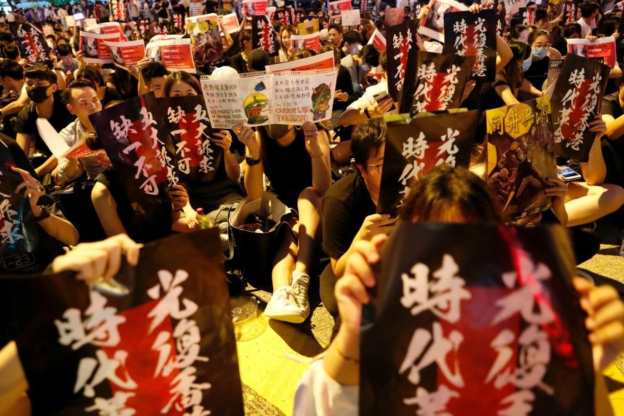 Protesters at a rally in Hong Kong, holding up signs asking for their five demands to be met. (REUTERS)