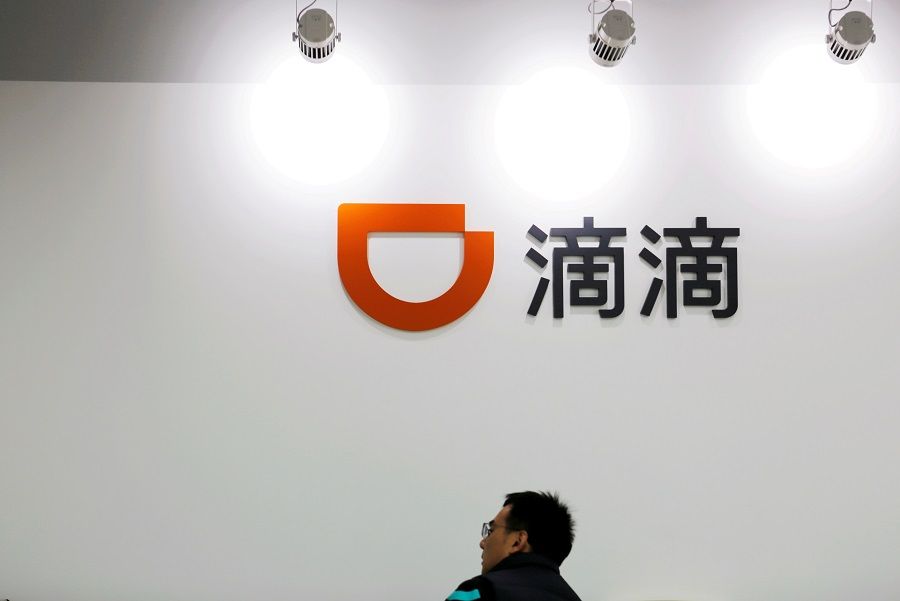 A man is seen under a Didi logo at the headquarters of Didi Chuxing in Beijing, China, 20 November 2020. (Florence Lo/File Photo/Reuters)