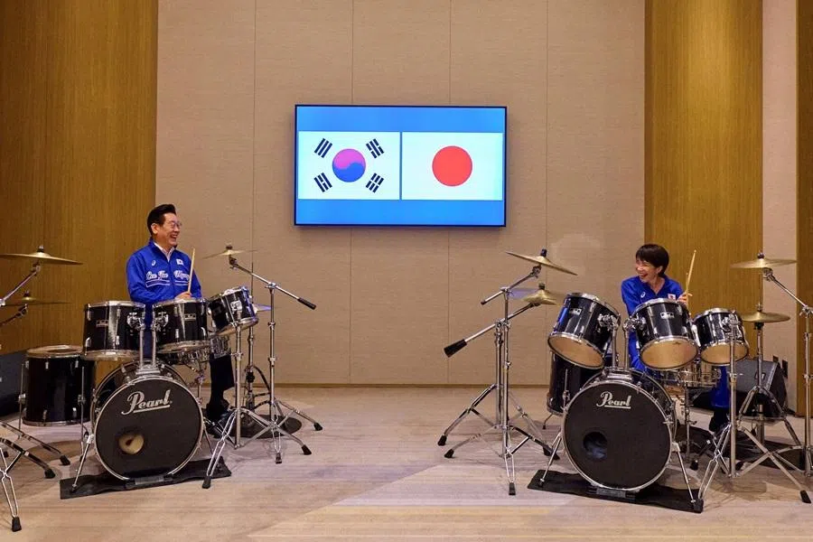 Japanese Prime Minister Sanae Takaichi and South Korean President Lee Jae Myung play drums after their meeting in Nara, western Japan, on 13 January 2026. (Yonhap via Reuters)