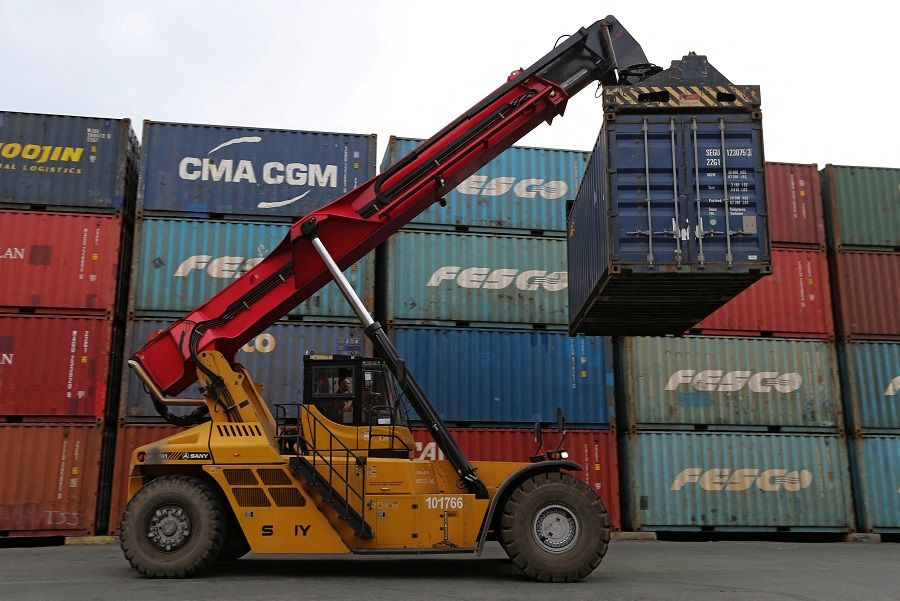 A vehicle moves a shipping container at a commercial port in Vladivostok, Russia, 22 October 2021. (Tatiana Meel/File Photo/Reuters)
