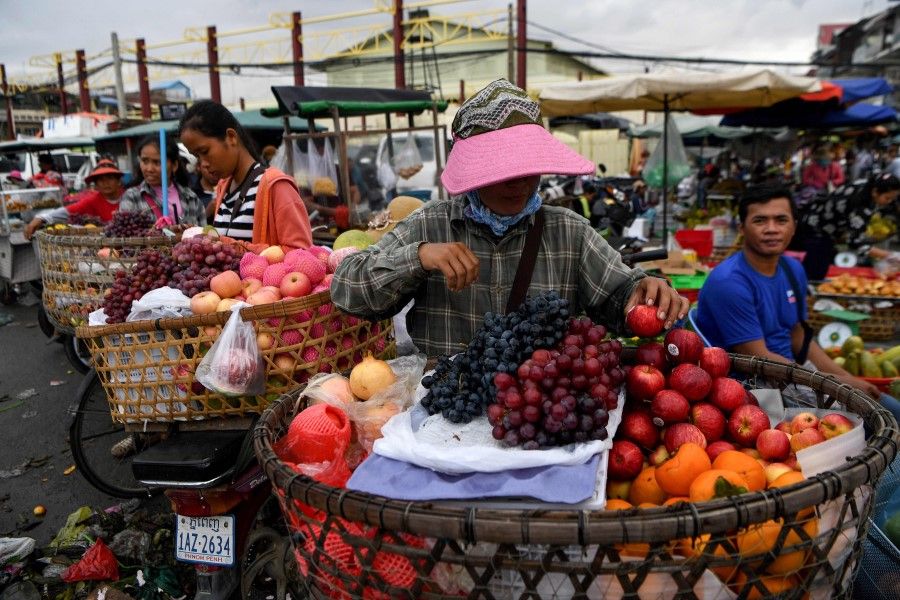A vendor prepares fruits for sale outside a market in Phnom Penh on 2 October 2020. (Tang Chhin Sothy/AFP)