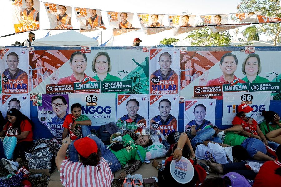 Supporters of presidential candidate Ferdinand "Bongbong" Marcos Jr, son and namesake of the late Philippine dictator, and vice-presidential candidate Sara Duterte-Carpio, daughter of Philippine President Rodrigo Duterte, rest while taking part in a campaign rally ahead of the 2022 national elections in Paranaque, Metro Manila, Philippines, 7 May 2022. (Willy Kurniawan/Reuters)