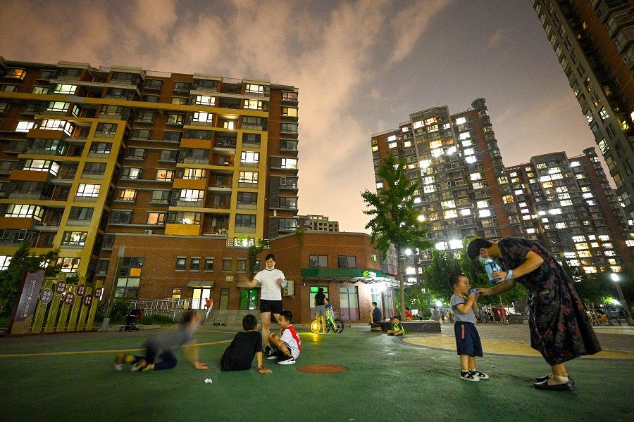 This photo taken on 17 August 2022 shows people relaxing in a residential complex in Beijing's Shangdi neighbourhood in China. (Noel Celis/AFP)