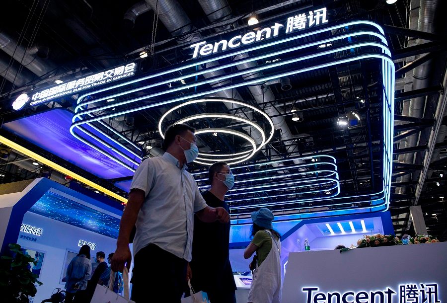 People walk past the Tencent booth at the China International Fair for Trade in Services (CIFTIS) in Beijing on 6 September 2020. (Noel Celis/AFP)