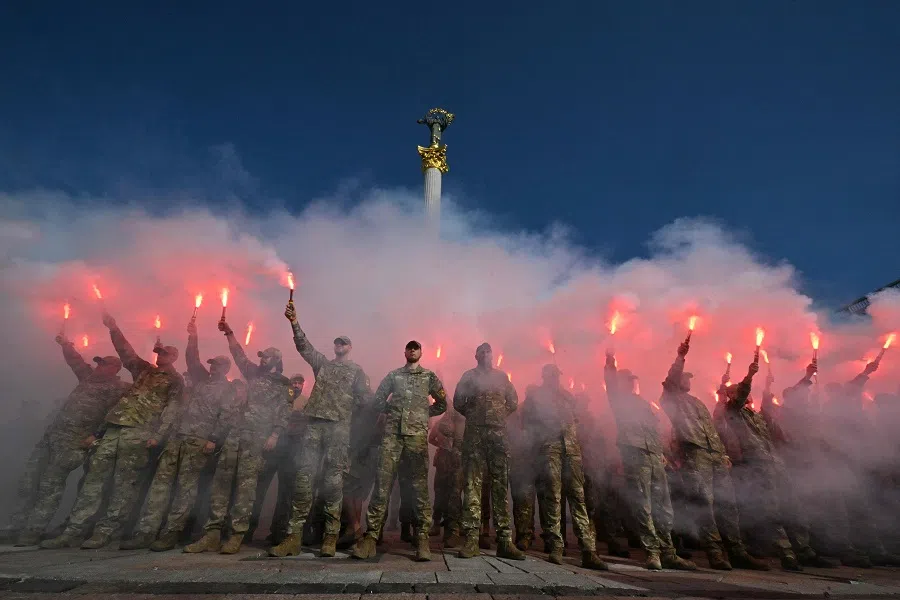 Servicemen of the Ukrainian Azov Brigade burn flares during a memorial event at Independence Square in Kyiv on 28 July 2024, marking the two-year anniversary of the Olenivka prison attack. (Sergei Supinsky/AFP)