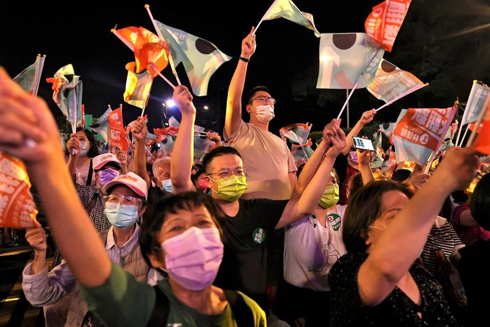 People wave flags at the ruling Democratic Progressive Party's pre-election campaign rally ahead of mayoral elections in Taipei, Taiwan, 12 November 2022. (Ann Wang/Reuters)