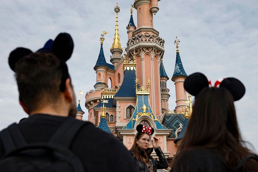 Visitors look on in front of the Sleeping Beauty-inspired castle at Disneyland Paris, in Marne-la-Vallee, Paris, France, on 16 October 2023. (Ian Langsdon/AFP)