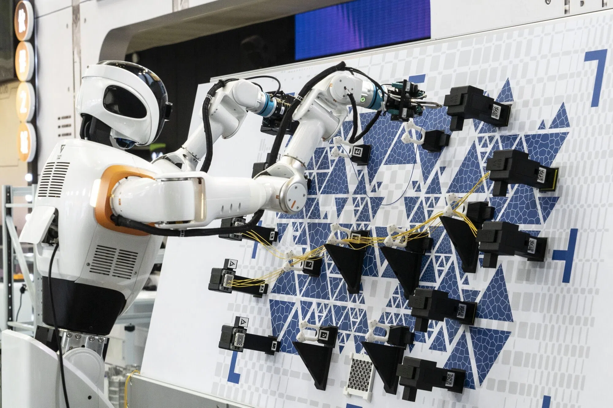 A humanoid robot demonstrates industrial applications at the TARS Robotics booth during a media preview of the World AI Conference (WAIC) in Shanghai, China, 16 July 2026.