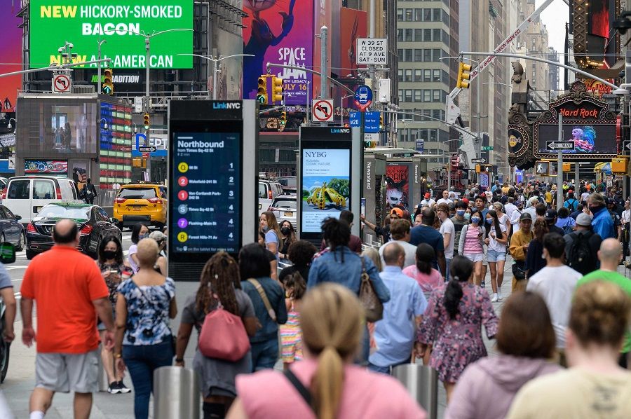 In this file photo taken on 13 July 2021, people walk through Times Square in New York City, US. (Angela Weiss/AFP)
