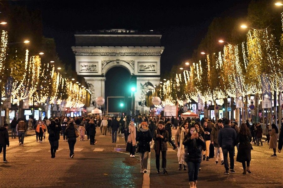 People walk along the Champs-Elysees avenue in Paris, France, on 20 November 2022. (Julien De Rosa/AFP)