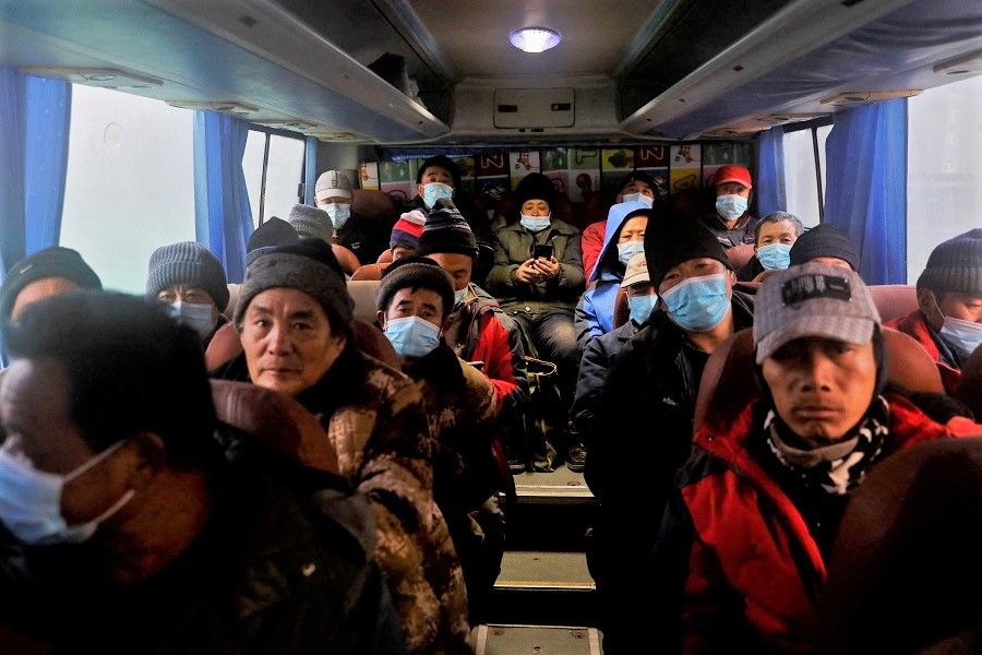Migrant workers travel home on a shuttle bus in Beijing, China, 31 January 2021. (Tingshu Wang/File Photo/Reuters)