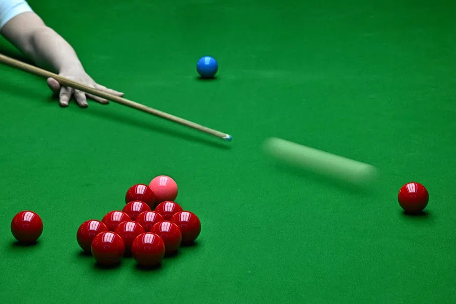 This photo taken on 6 May 2025 shows a man playing snooker at a billiard club in Beijing. (Pedro Pardo/AFP)