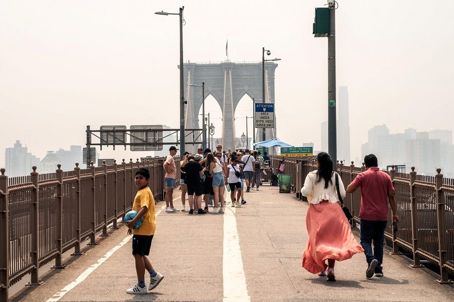 People walk over the Brooklyn Bridge on 30 June 2023 in New York City, US. (David Dee Delgado/Getty Images/AFP)