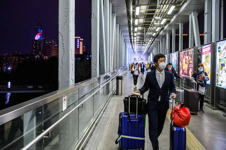 Passengers are seen wearing masks as they arrive in Hong Kong from Shenzhen (back, left) hours before the closing of the Lo Wu border crossing in Hong Kong on 3 February 2020. (Anthony Wallace/AFP)