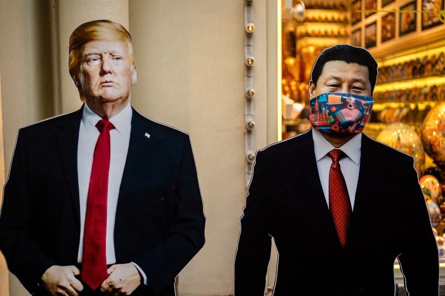 Cardboard figures of Chinese President Xi Jinping (R) wearing a face mask and US President Donald Trump (L) stand in front of a souvenir shop in downtown Moscow, 3 June 2020. (Dimitar Dilkoff/AFP