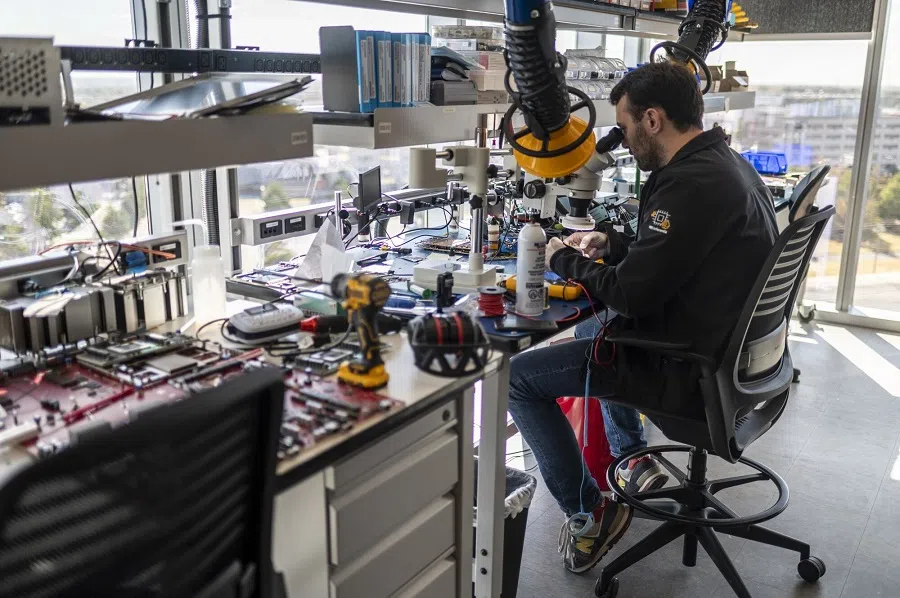A worker uses a microscope to inspect a chip at Annapurna Labs on 21 October 2024 in Austin, US. (Sergio Flores/Bloomberg)