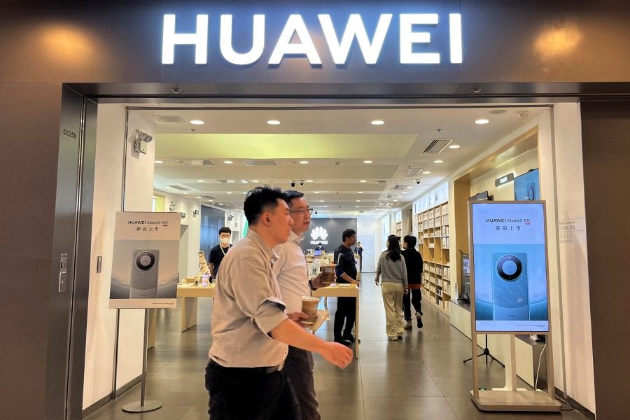 People walk past a Huawei store with advertisements for the Mate 60 series smartphones, at a shopping mall in Beijing, China, on 30 August 2023. (Yelin Mo/Reuters)