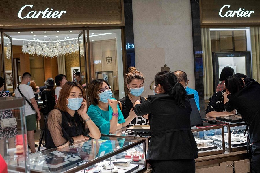 People look at jewellery in a mall in Beijing on 14 August 2020. (Nicolas Asfouri/AFP)