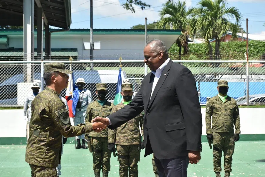 This handout photo taken on 1 February 2023 and released by Western Mindanao Command (WESTMINCOM) shows US Secretary of Defense Lloyd Austin (right) shaking hands with Westmincom commander Lieutenant General Roy Galido (left) shortly after arriving at the Westmincom headquarters in Zamboanga City, in the southern island of Mindanao. (Handout/Western Mindanao Command/AFP)