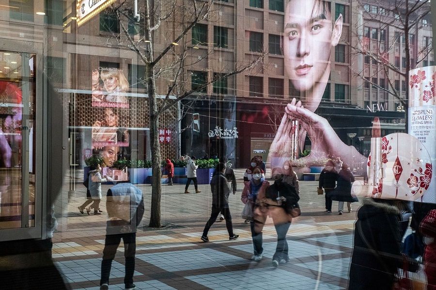 Pedestrians reflected in a store window in the Wangfujing shopping area in Beijing, China, on 10 February 2023. (Bloomberg)