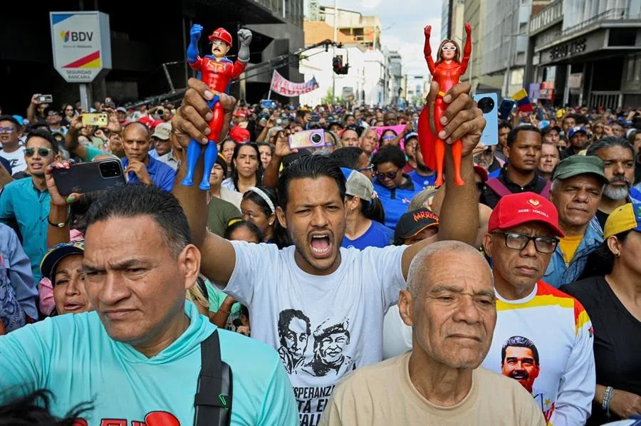 A demonstrator holds action figures of "Super Bigote" (Super Mustache) and "Cilita", superheroes inspired by US-deposed Venezuelan President Nicolás Maduro and his wife Cilia Flores, during a march outside the National Assembly, on the day Vice-President Delcy Rodríguez was formally sworn in as the country's interim president, in Caracas, Venezuela, on 5 January 2026.