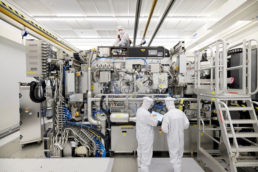 Employees are seen working on the final assembly of ASML's TWINSCAN NXE:3400B semiconductor lithography tool with its panels removed, in Veldhoven, Netherlands, in this picture taken 4 April 2019. (Bart van Overbeeke Fotografie/ASML/Handout via Reuters)