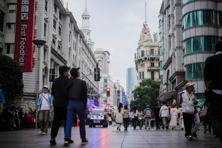People walk on a street on the day of the opening session of the 20th National Congress of the Communist Party of China, in Shanghai, China, 16 October 2022. (Aly Song/Reuters)